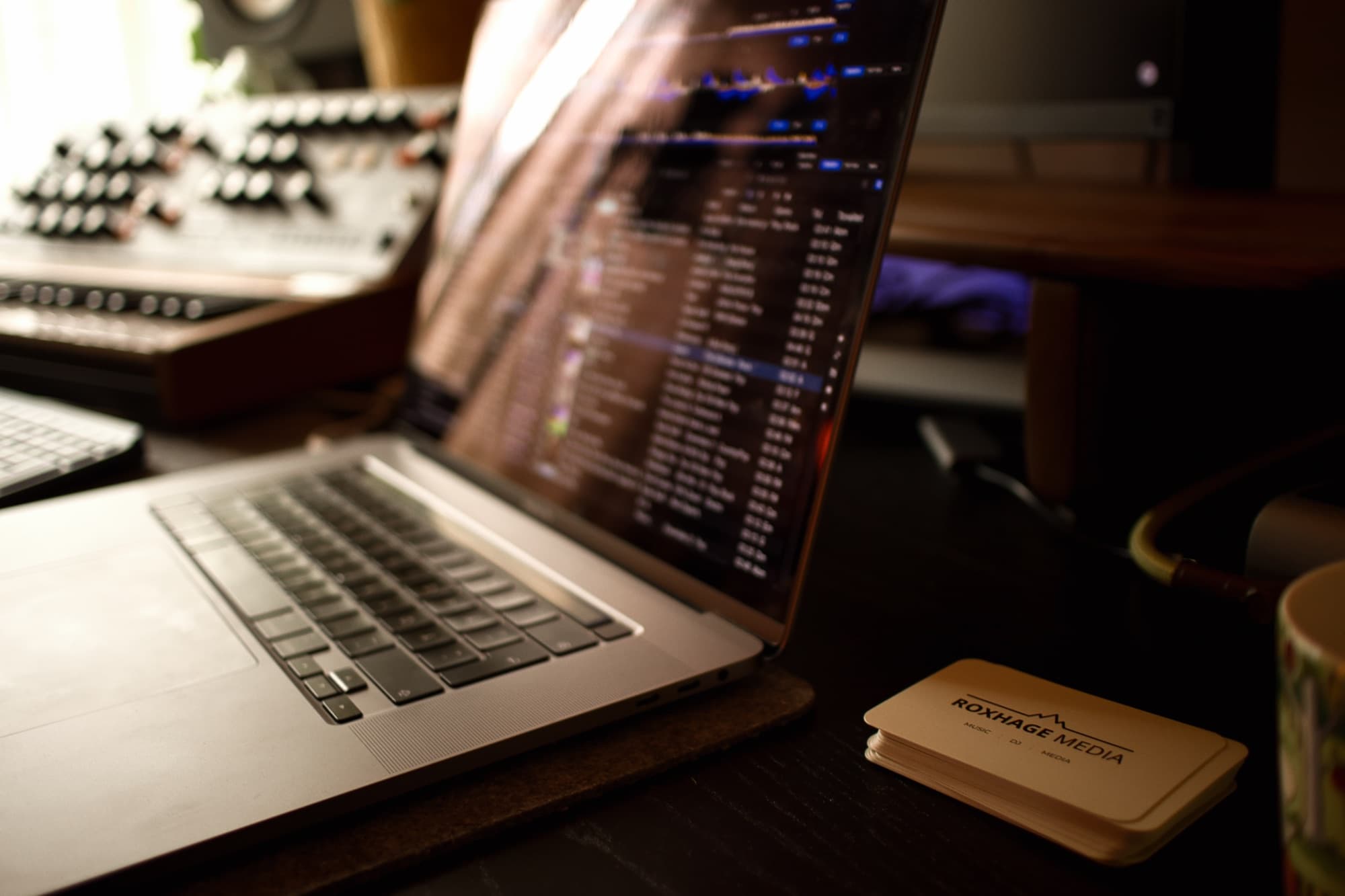 Laptop med musikprogram och Roxhage Media visitkort under planeringen av eventet